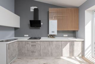 Cuisine moderne aux murs gris avec chaudière murale blanche fixée près d'un habillage en lattes de bois