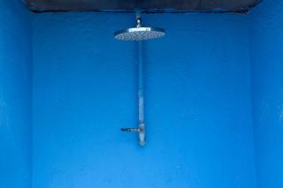 Pomme de douche fixe sur un mur peint en bleu vif