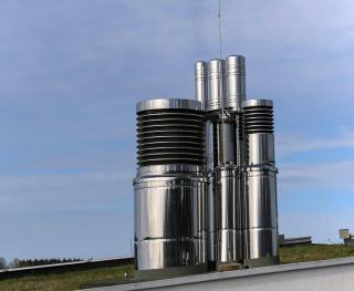 Conduits de fumée en inox à double paroi groupés sur un toit-terrasse